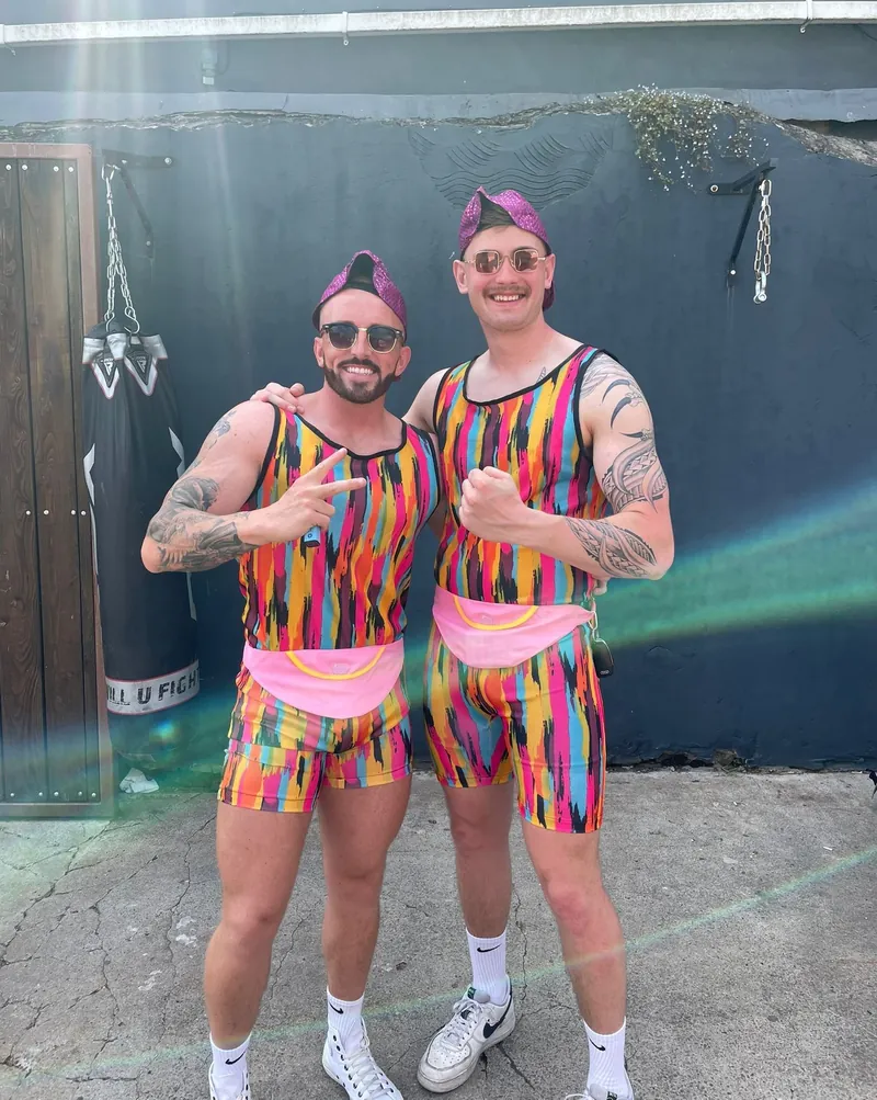 Rhys, on the left, in a rainbow fancy-dress outfit and headband, beside a friend in the same costume